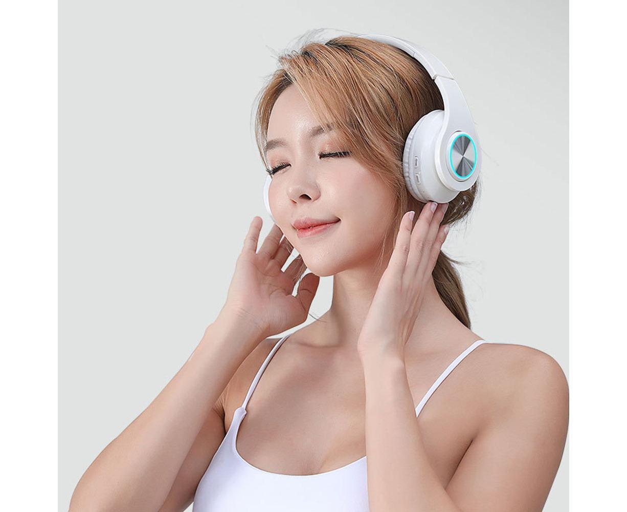 Woman wearing JX-59 white Bluetooth headphones with eyes closed, lifestyle listening shot