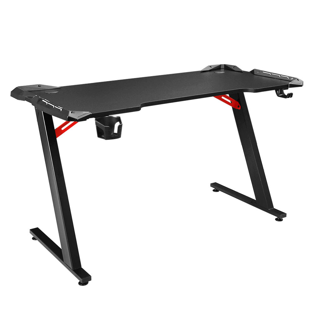 Artiss 120cm RGB gaming desk in black with red Z-frame supports, cup holder and headphone hook, angled view