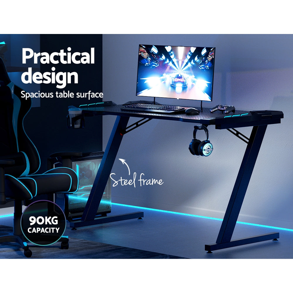 Artiss 120cm RGB gaming desk feature callout showing 90kg capacity steel frame and spacious table surface