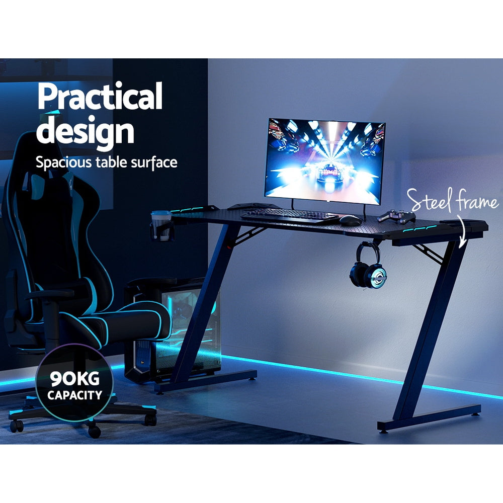 Artiss 140cm RGB gaming desk feature callout showing 90kg capacity steel frame and spacious table surface