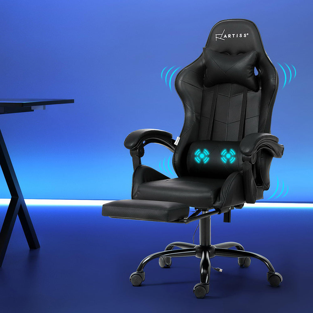 Artiss black 2-point massage gaming chair beside a desk in a blue-lit gaming room with vibration icons
