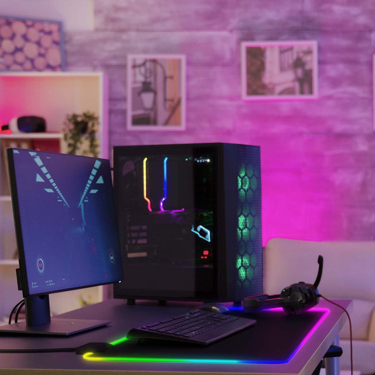 Laser RGB LED gaming mouse pad lighting up a gaming desk with PC tower, monitor and headset setup